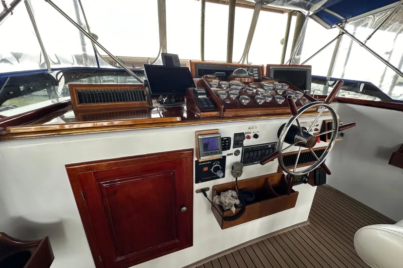 Slide: The Image of Cockpit of a 1980 Bertram 58 Convertible yacht with classic wooden dashboard and steering wheel. - 24