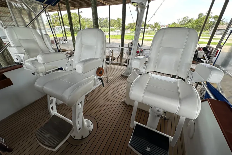 Slide: The Image of White captain chairs on a 1980 Bertram 58 Convertible yacht deck. - 26