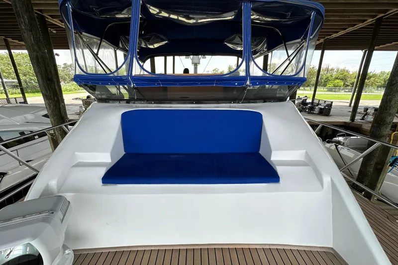 Slide: The Image of 1980 Bertram 58 Convertible yacht with blue cushioned seating on deck. - 27