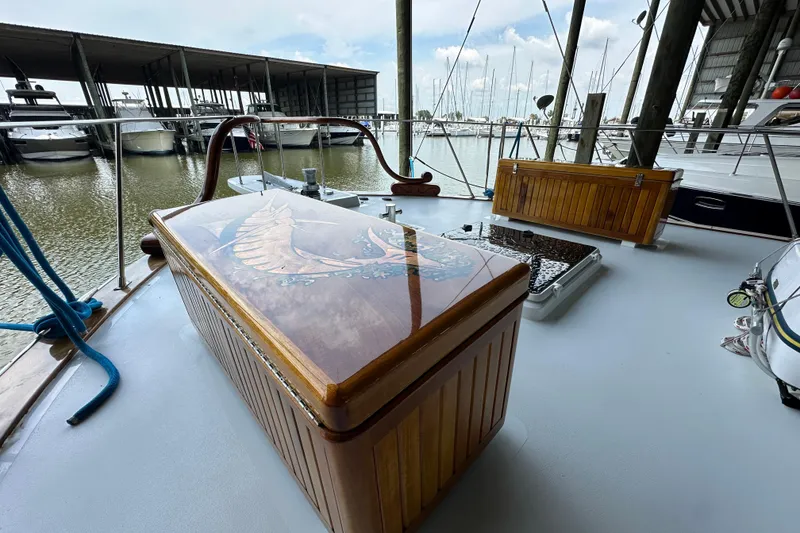 Slide: The Image of 1980 Bertram 58 Convertible yacht deck with wooden storage, docked at marina. - 32