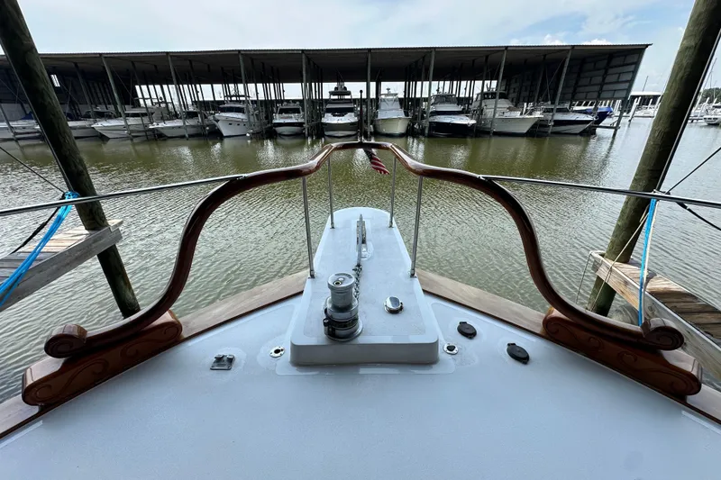 Slide: The Image of Bow view of a 1980 Bertram 58 Convertible yacht docked at a marina. - 33