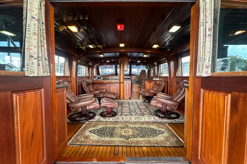 Slide: The Image of Luxurious interior of a 1980 Bertram 58 Convertible yacht with leather seating and wood paneling. - 34