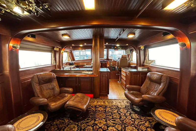 Slide: The Image of Luxurious interior of a 1980 Bertram 58 Convertible yacht with leather seating and wood paneling. - 37