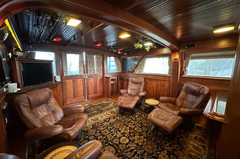Slide: The Image of Luxurious interior of a 1980 Bertram 58 Convertible yacht with leather seating and wood paneling. - 40