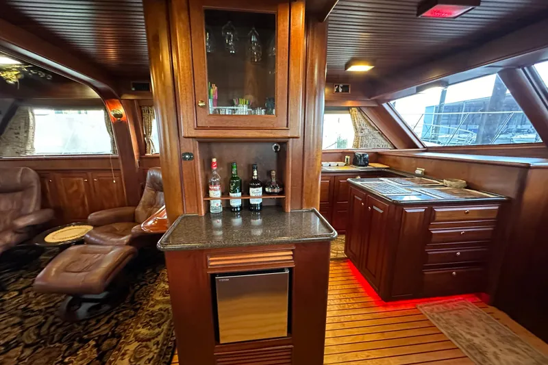 Slide: The Image of Luxurious interior of a 1980 Bertram 58 Convertible yacht with wood cabinetry and seating. - 42