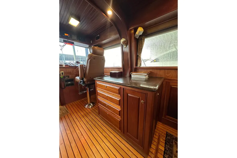 Slide: The Image of Interior of 1980 Bertram 58 Convertible yacht with wooden cabinetry and captain's chair. - 43