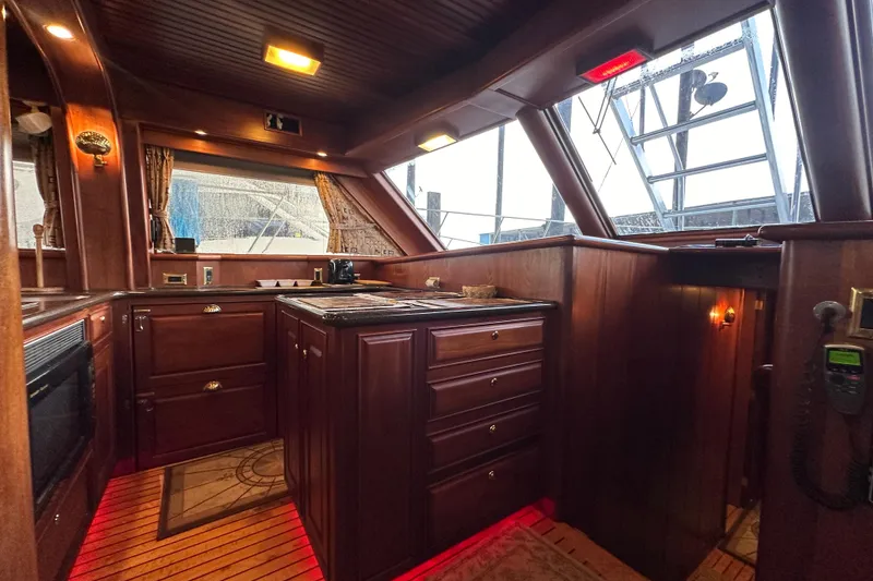 Slide: The Image of Luxurious wooden interior of a 1980 Bertram 58 Convertible yacht kitchen. - 45