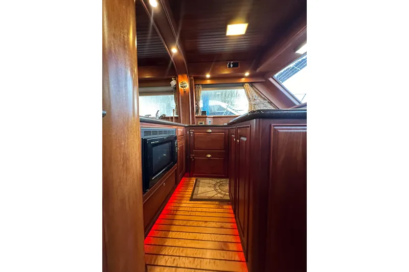 Slide: The Image of Luxurious wooden interior of a 1980 Bertram 58 Convertible yacht kitchen. - 46