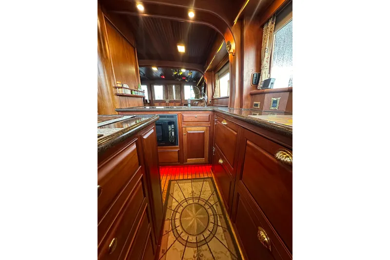 Slide: The Image of Luxurious wooden interior of a 1980 Bertram 58 Convertible yacht kitchen. - 48
