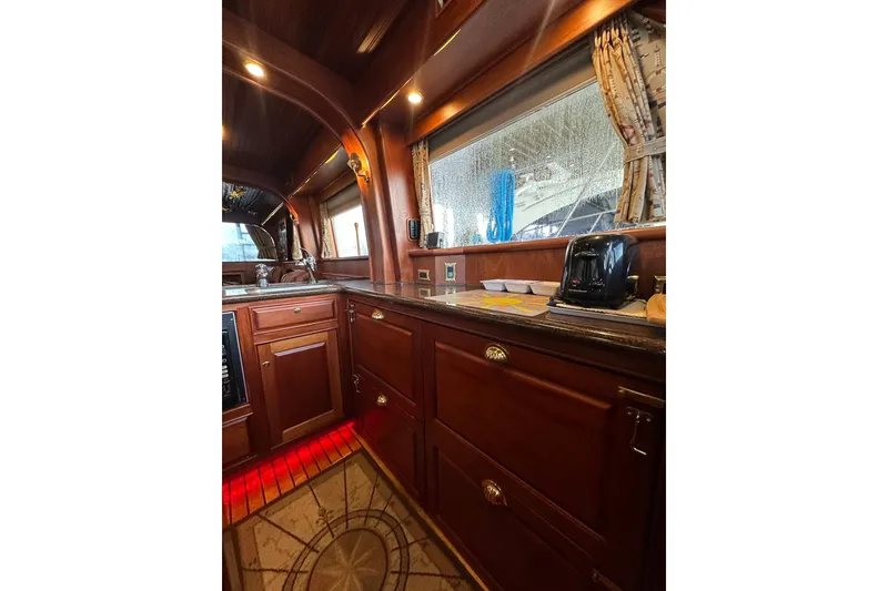 Slide: The Image of Interior of 1980 Bertram 58 Convertible yacht with wooden cabinetry and modern appliances. - 49