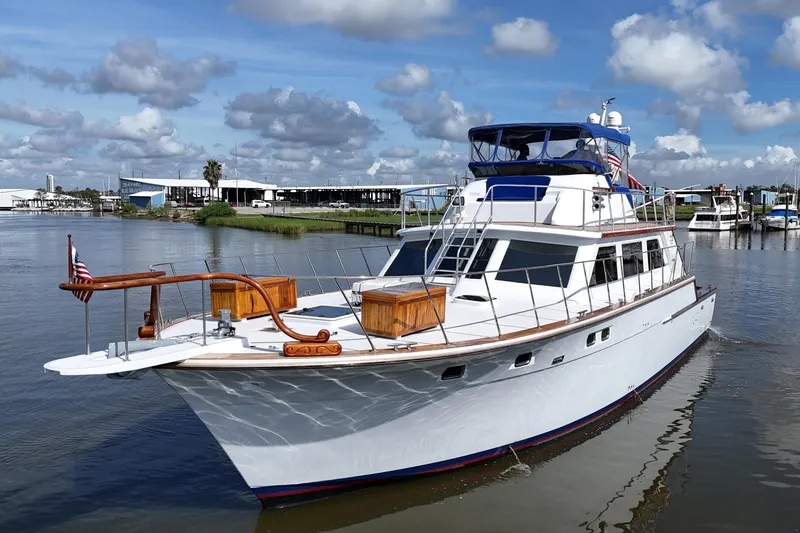Slide: The Image of 1980 Bertram 58 Convertible yacht on calm water under a partly cloudy sky. - 5