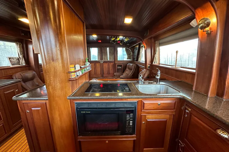 Slide: The Image of Luxurious wooden interior of a 1980 Bertram 58 Convertible yacht kitchen. - 50