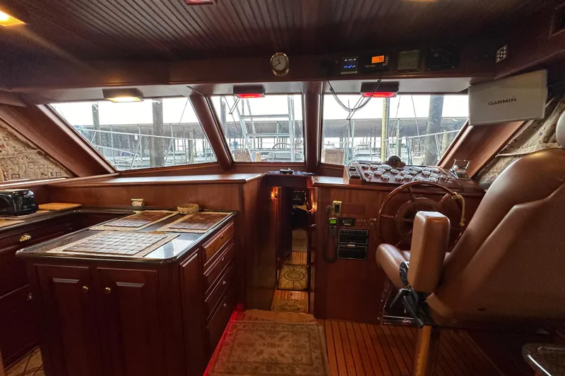 Slide: The Image of Interior of a 1980 Bertram 58 Convertible yacht with wooden helm and navigation equipment. - 51