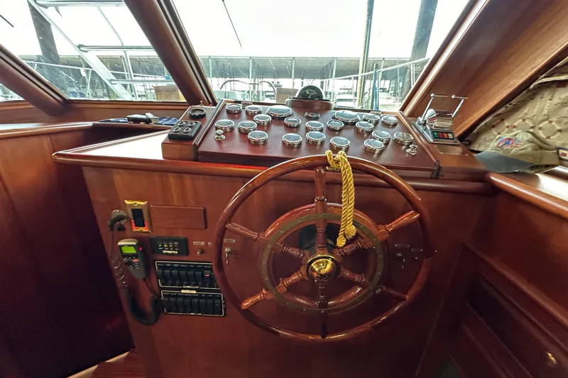 Slide: The Image of Helm of 1980 Bertram 58 Convertible yacht with wooden steering wheel and control panel. - 52