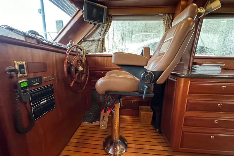 Slide: The Image of Interior helm of 1980 Bertram 58 Convertible yacht with captain's chair and wooden accents. - 53