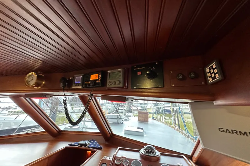 Slide: The Image of Interior of 1980 Bertram 58 Convertible yacht with navigation equipment and wooden paneling. - 55