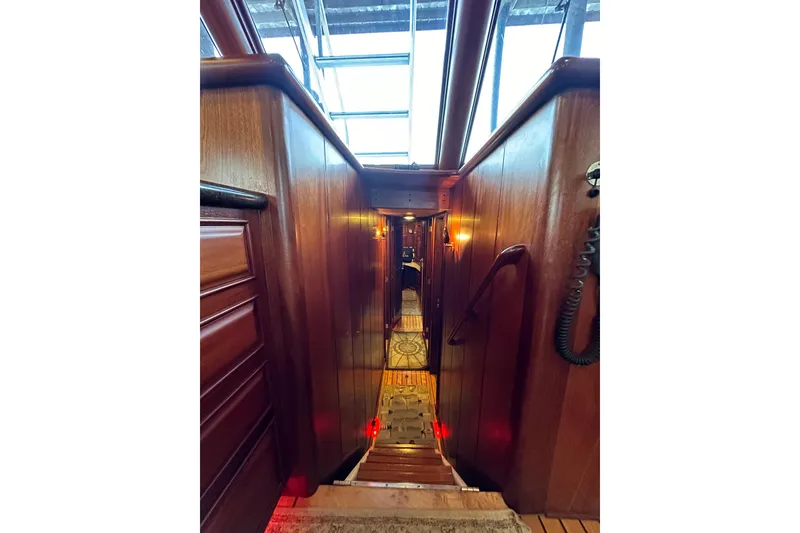 Slide: The Image of Interior view of 1980 Bertram 58 Convertible yacht with wooden paneling and stairs. - 56