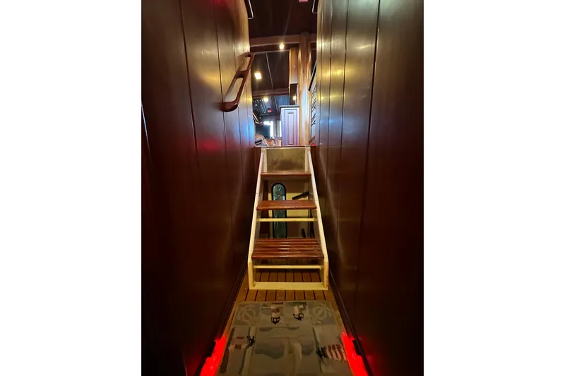 Slide: The Image of Interior staircase of 1980 Bertram 58 Convertible yacht with wooden paneling. - 58