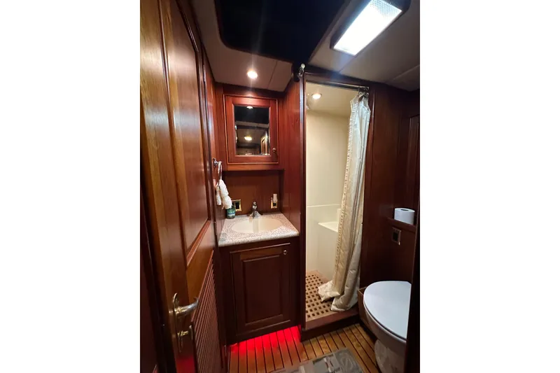 Slide: The Image of Luxurious bathroom interior of 1980 Bertram 58 Convertible yacht with wood accents. - 61