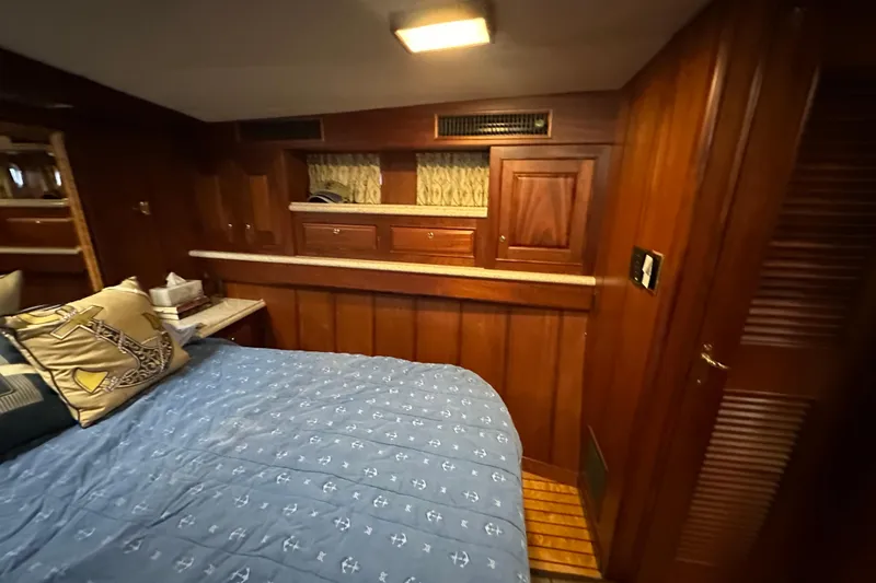 Slide: The Image of Cozy cabin interior of 1980 Bertram 58 Convertible with wood paneling and nautical bedding. - 66