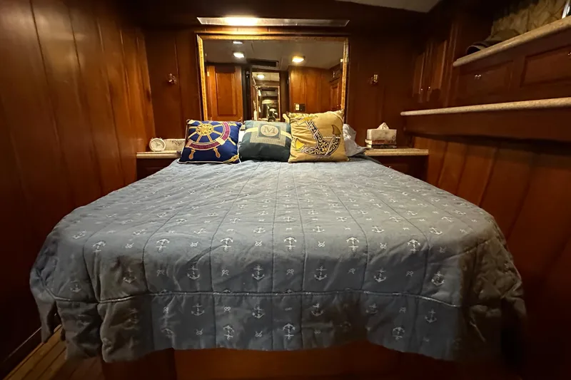 Slide: The Image of Cozy bedroom interior of 1980 Bertram 58 Convertible yacht with nautical-themed bedding. - 68