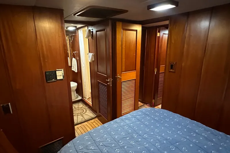 Slide: The Image of Interior of 1980 Bertram 58 Convertible yacht with wood paneling and cozy bedroom. - 69