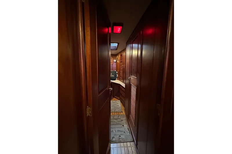 Slide: The Image of Interior hallway of a 1980 Bertram 58 Convertible yacht with wooden paneling. - 77