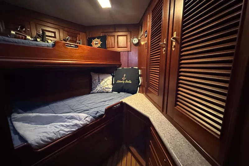 Slide: The Image of Cozy cabin interior of 1980 Bertram 58 Convertible yacht with wooden furnishings and bunk beds. - 79
