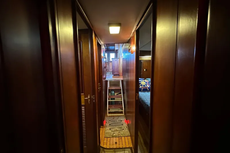 Slide: The Image of Narrow hallway inside 1980 Bertram 58 Convertible yacht with wooden paneling and cozy cabin. - 83