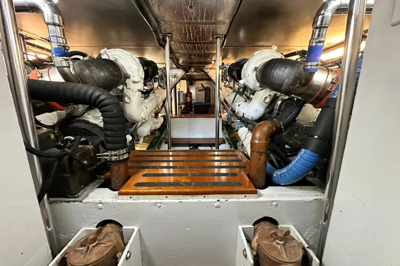 Slide: The Image of Engine room of a 1980 Bertram 58 Convertible yacht, showcasing dual engines and mechanical components. - 85
