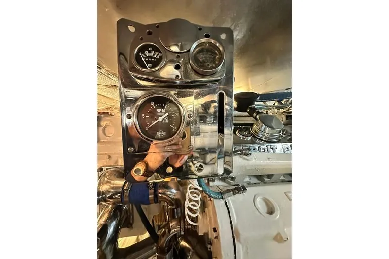 Slide: The Image of Engine control panel of a 1980 Bertram 58 Convertible boat, featuring RPM and pressure gauges. - 93