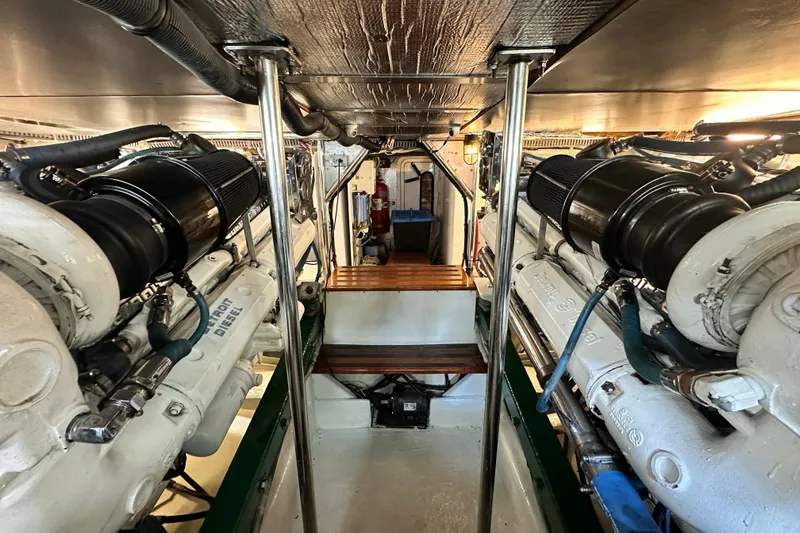 Slide: The Image of Engine room of a 1980 Bertram 58 Convertible yacht, showcasing twin diesel engines. - 94