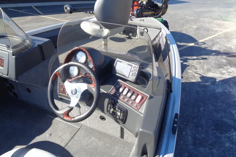 Slide: The Image of 2015 Alumacraft Competitor 165 CS boat dashboard with steering wheel and control panel. - 10