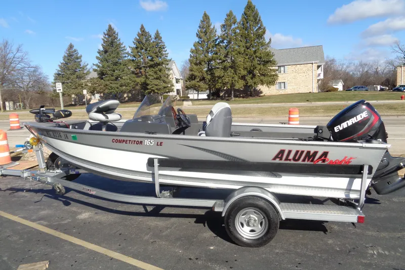 Slide: The Image of 2015 Alumacraft Competitor 165 CS fishing boat on trailer, parked outdoors. - 2