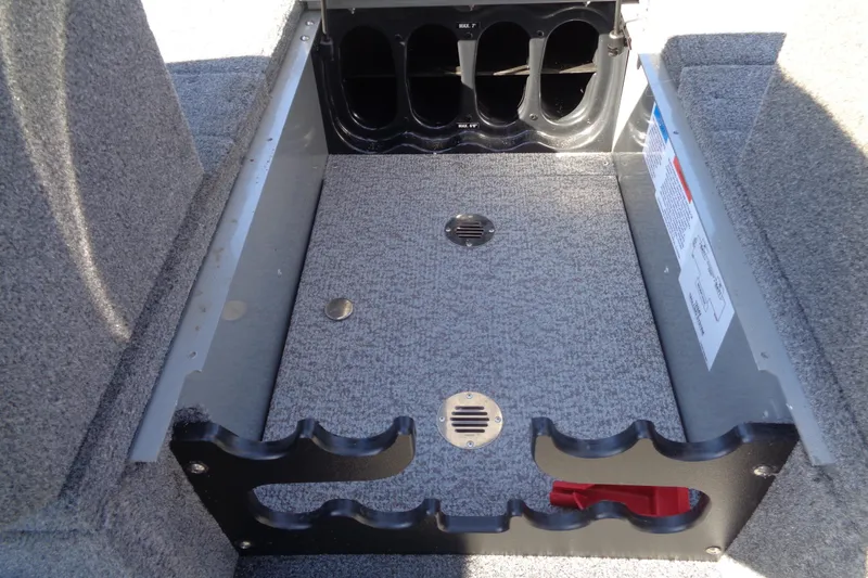 Slide: The Image of 2015 Alumacraft Competitor 165 CS boat storage compartment with rod holders and carpeted interior. - 25