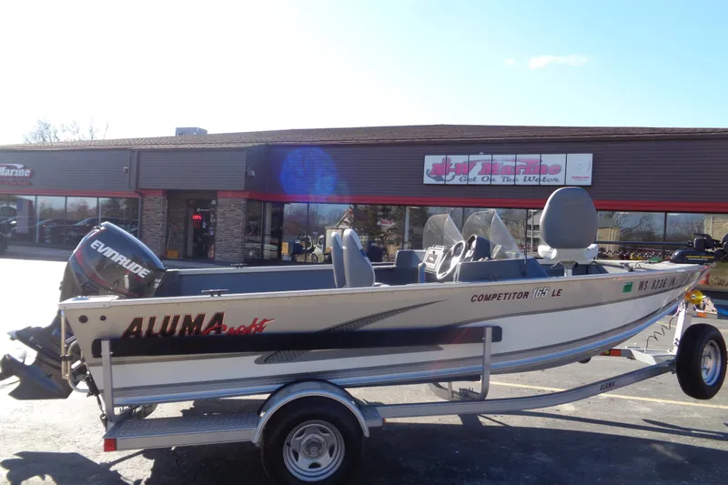 Slide: The Image of 2015 Alumacraft Competitor 165 CS boat on trailer outside a marine store. - 3