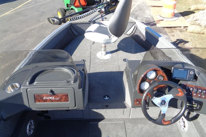 Slide: The Image of 2015 Alumacraft Competitor 165 CS boat interior with steering console and seating. - 7