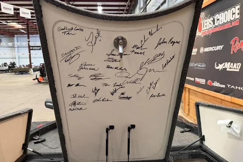 Slide: The Image of 2021 Ranger Z520L boat lid with multiple autographs in a showroom setting. - 20