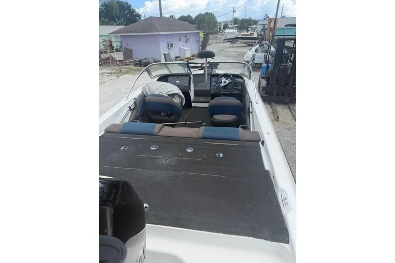 Slide: The Image of 2008 Champion 214 SX boat interior with seating and steering wheel, parked outdoors. - 11