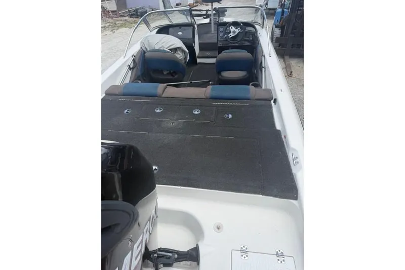 Slide: The Image of 2008 Champion 214 SX boat interior with seating and steering wheel, featuring a Mercury engine. - 12