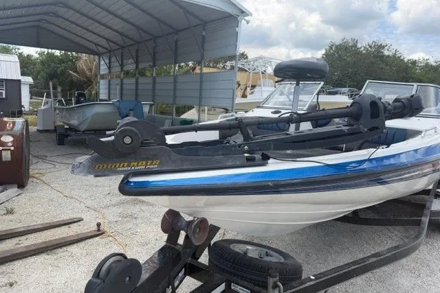 Slide: The Image of 2008 Champion 214 SX boat on trailer under metal canopy, featuring Minn Kota trolling motor. - 3