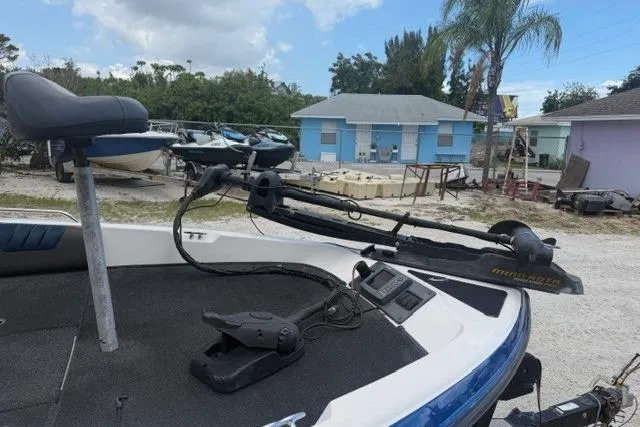 Slide: The Image of 2008 Champion 214 SX boat with trolling motor and seat, parked outdoors. - 5