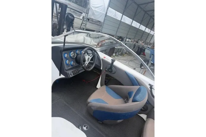 Slide: The Image of Interior of a 2008 Champion 214 SX boat, featuring steering wheel and dashboard controls. - 7