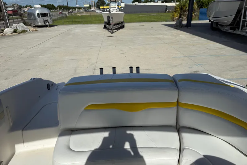 Slide: The Image of 2002 Chaparral 220 SSi boat interior with yellow-accented seating in a parking area. - 14