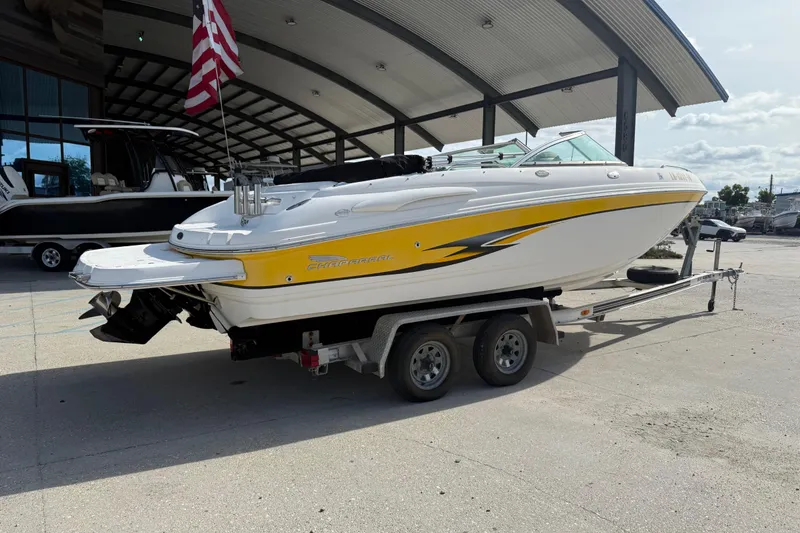 Slide: The Image of 2002 Chaparral 220 SSi boat on trailer, featuring yellow and white design, parked outdoors. - 4