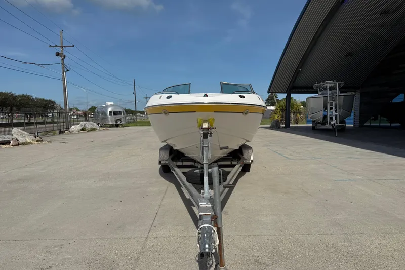 Slide: The Image of 2002 Chaparral 220 SSi boat on trailer, parked outdoors under clear sky. - 9