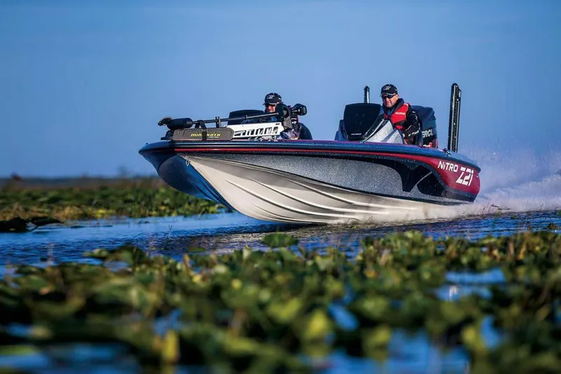 Slide: The Image of Manufacturer Provided Image: 2018 Nitro Z21 Pro boat speeding on a lake surrounded by greenery. - 2