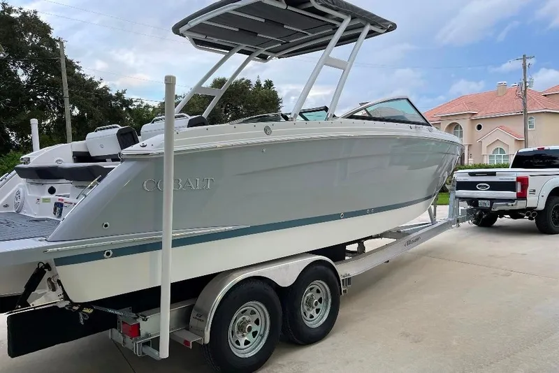 Slide: The Image of 2022 Cobalt R8 Outboard boat on trailer, parked in driveway near a house. - 3
