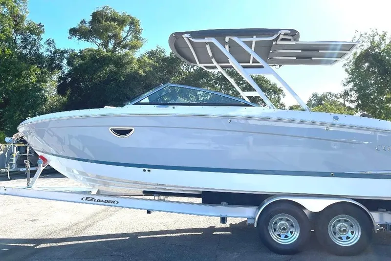 Slide: The Image of 2022 Cobalt R8 Outboard boat on trailer, parked outdoors with trees in background. - 5