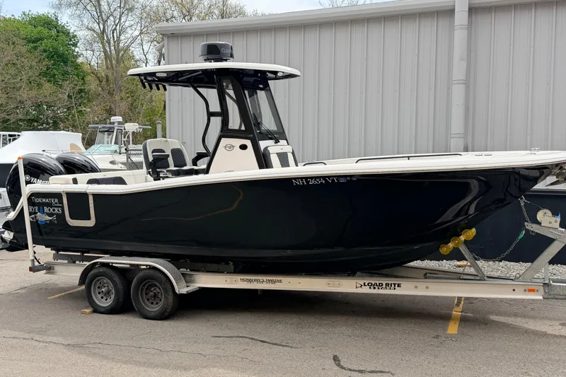 The Image of 2024 Tidewater 256 LXF boat on trailer, parked outdoors near a building. - 0